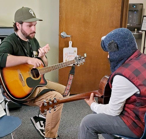 7th-12th graders playing guitars in the afterschool program