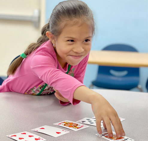 Kinder-6th Grader playing cards in the afterschool program